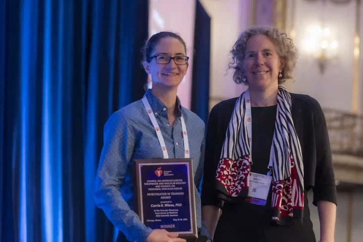 Carrie holding the plaque for the ATVB Investigator in Training Award beside a member of the ATVB awards committee.